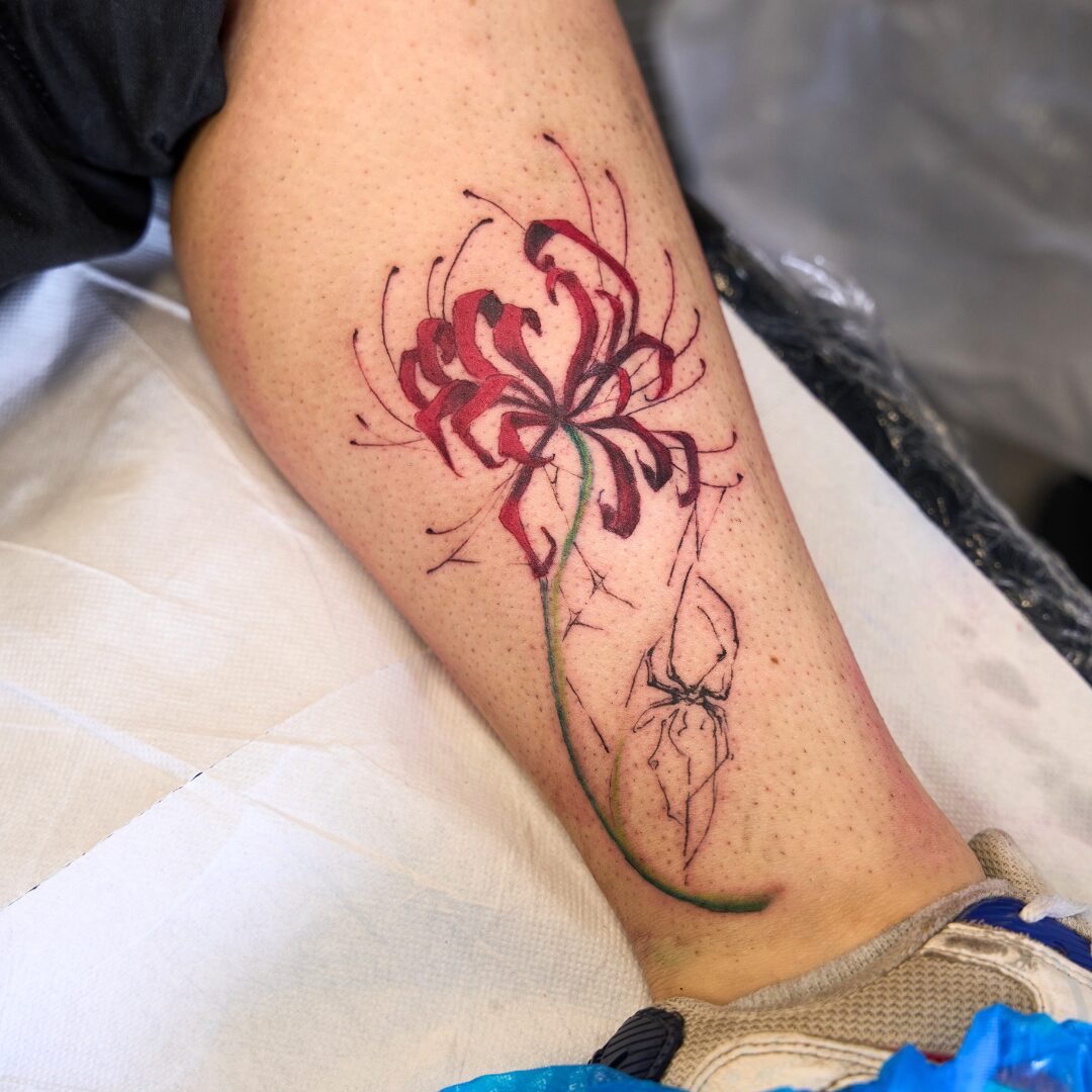 Painterly style flower tattoo on the calf